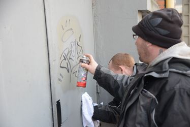 Le service anti-tags entrain d'enlever un tag sur un mur