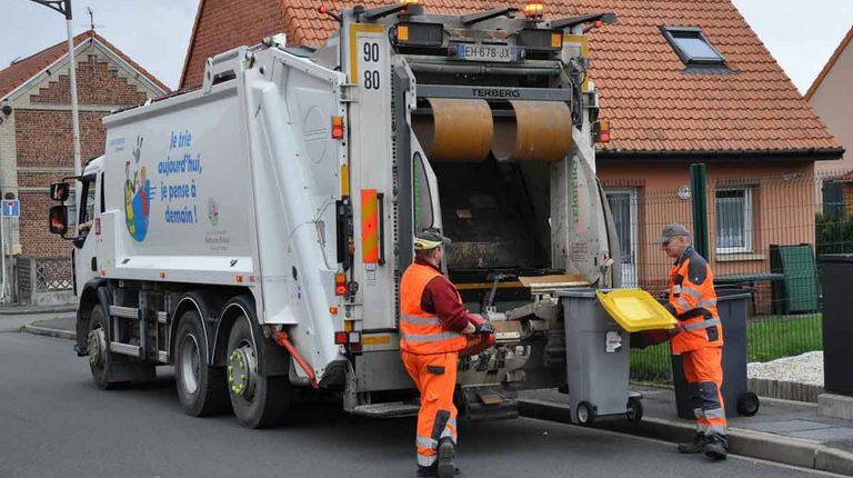 les rippeurs entrain de vider les poubelles dans le camion poubelle